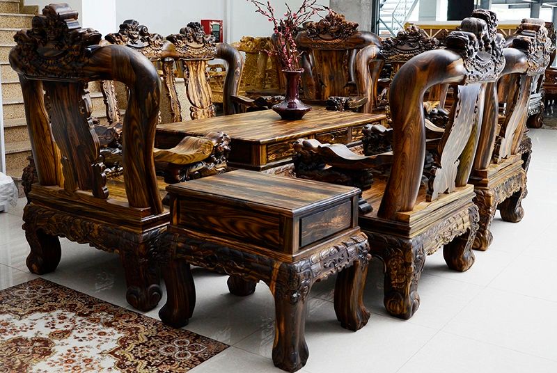 Bộ bàn ghế sa lông bằng gỗ mun sọc vân được trang trí giữa phòng khách của gia đình